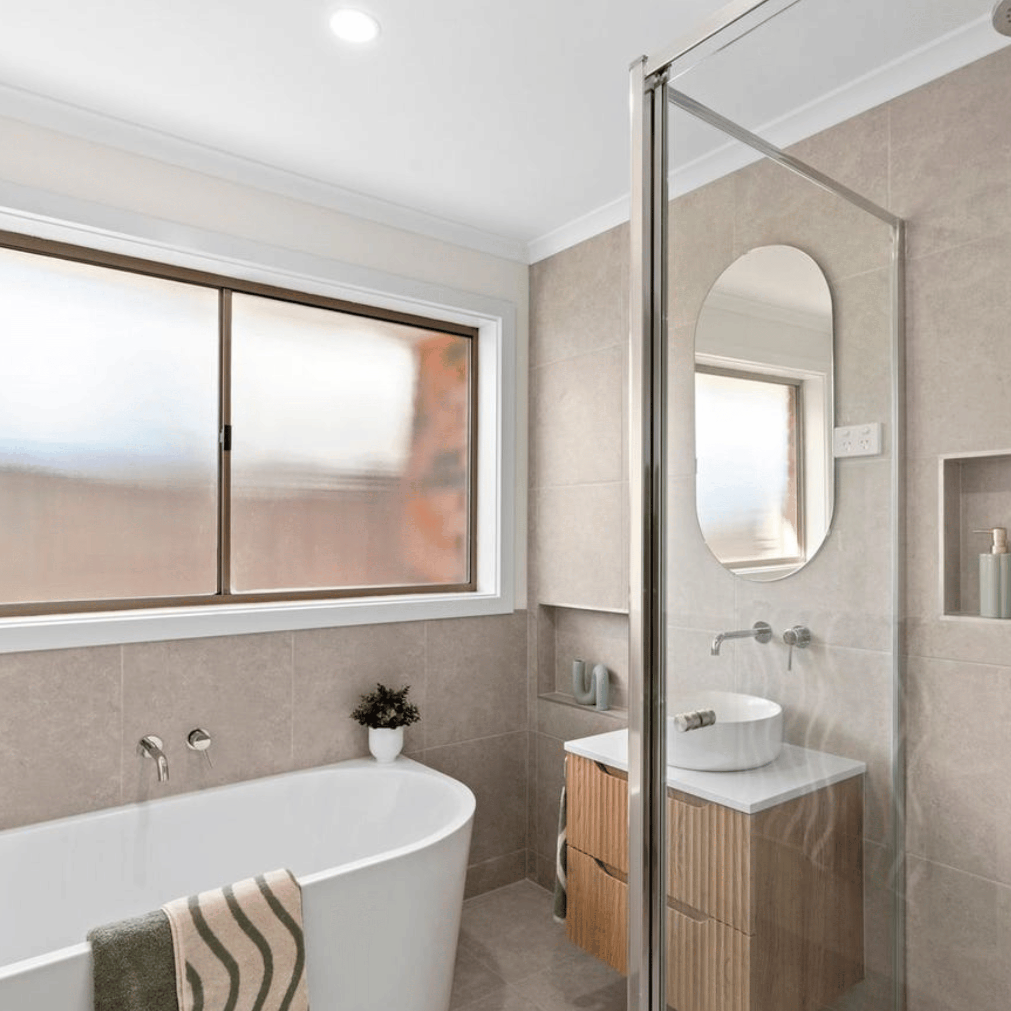 Modern bathroom with freestanding bathtub, shower area, and vanity unit.